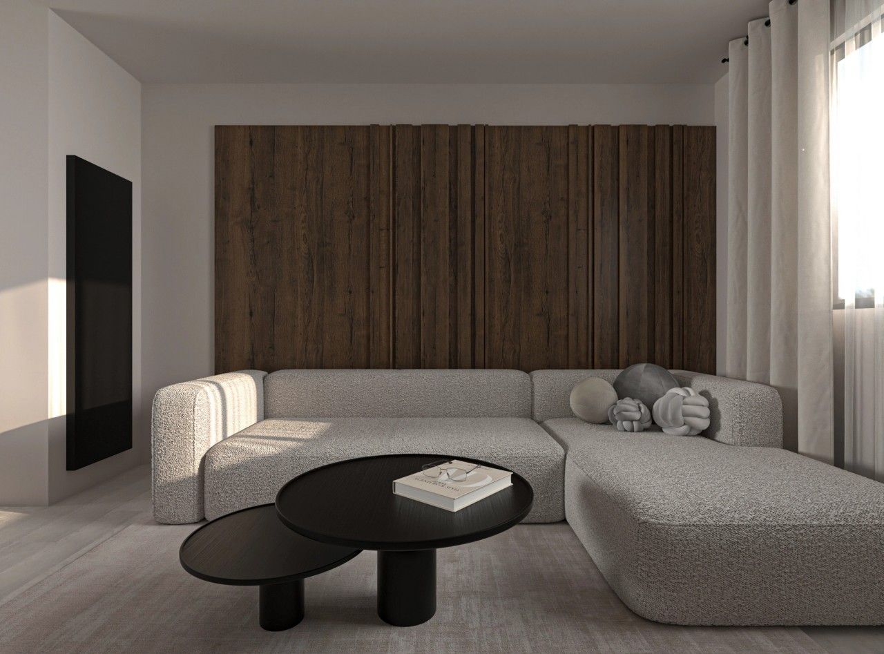 Vue intérieure du séjour rénové à Herstal, avec grand canapé d’angle clair, tables basses noires, parement mural en bois foncé et cheminée verticale contemporaine.