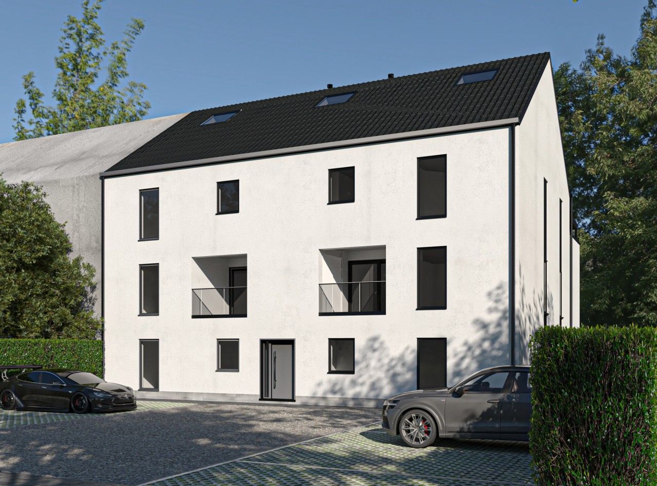 Vue en perspective d’un immeuble résidentiel de six appartements à Oupeye, avec crépi blanc, toiture sombre, balcons en retrait et espaces de stationnement paysagers.