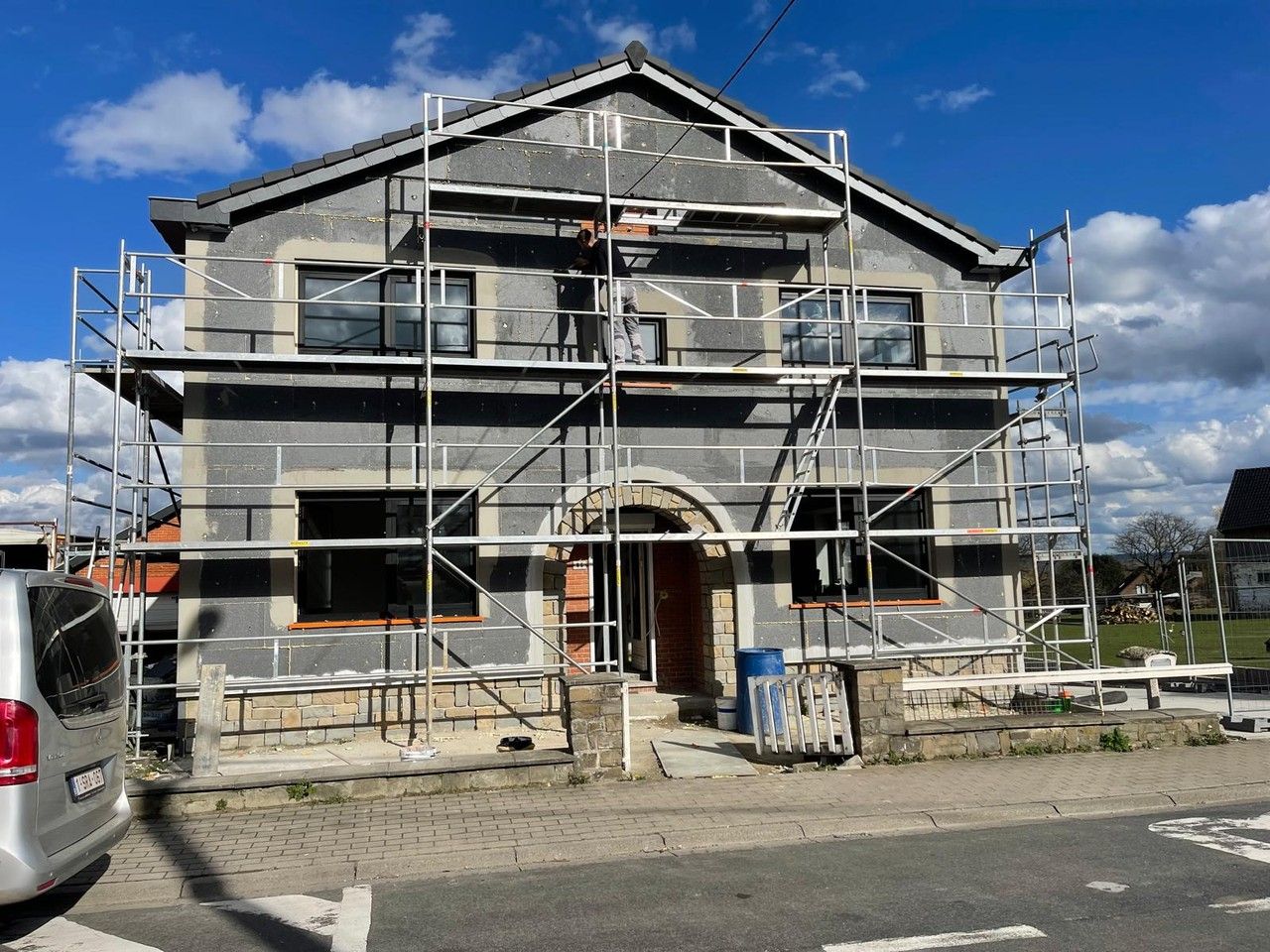 Façade avant de l’habitation à Vottem en cours de rénovation, avec échafaudages, nouvelles maçonneries et nouveaux châssis.