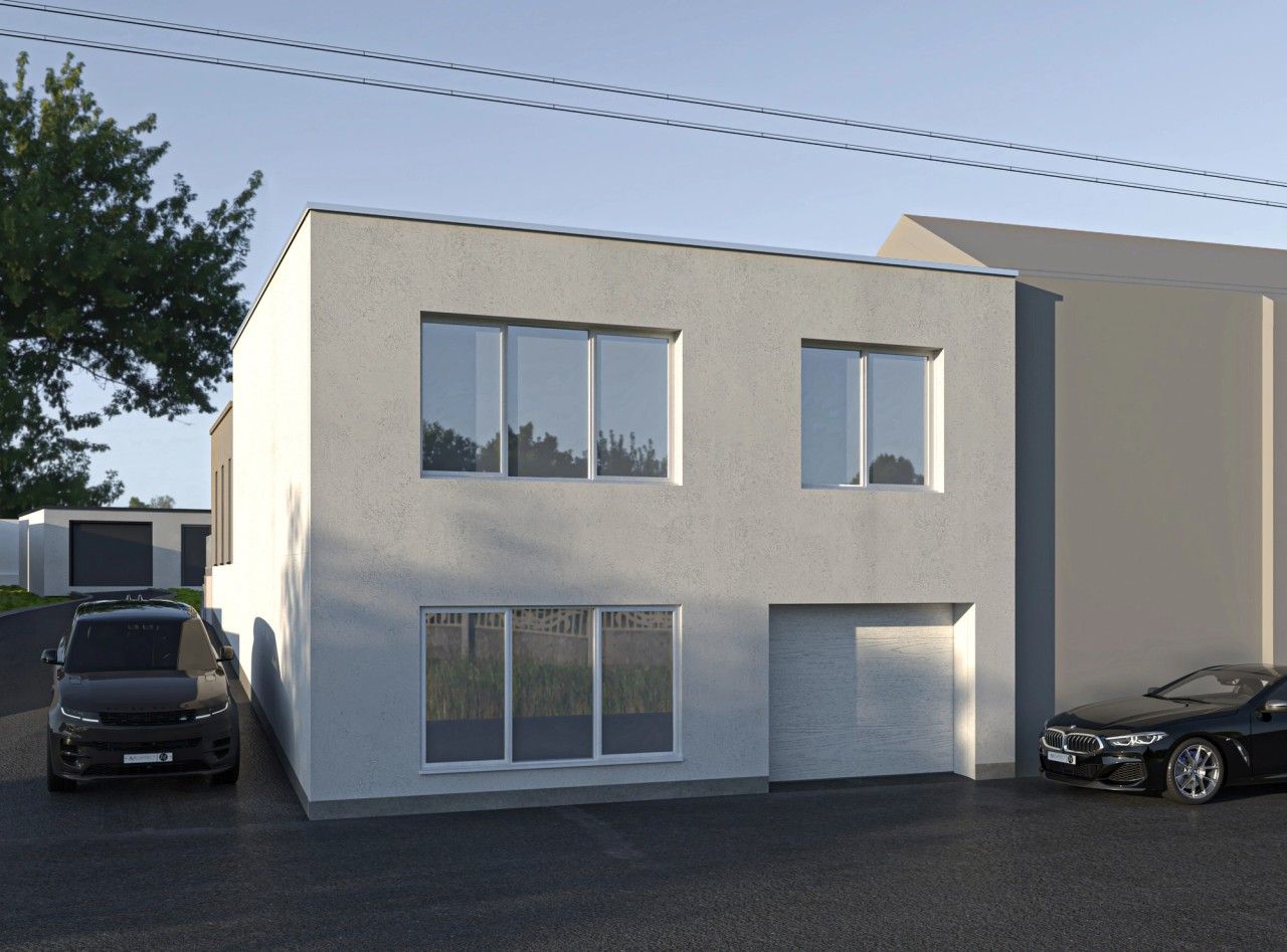 Façade avant rénovée d’une maison unifamiliale à Engis, avec crépi clair, toiture plate, châssis blancs et garage intégré.