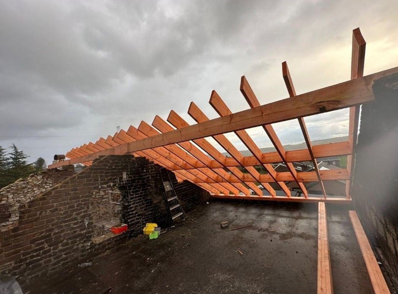 Charpente en bois en cours de reconstruction sur une habitation à Amay dans le cadre de la rénovation énergétique de la toiture.