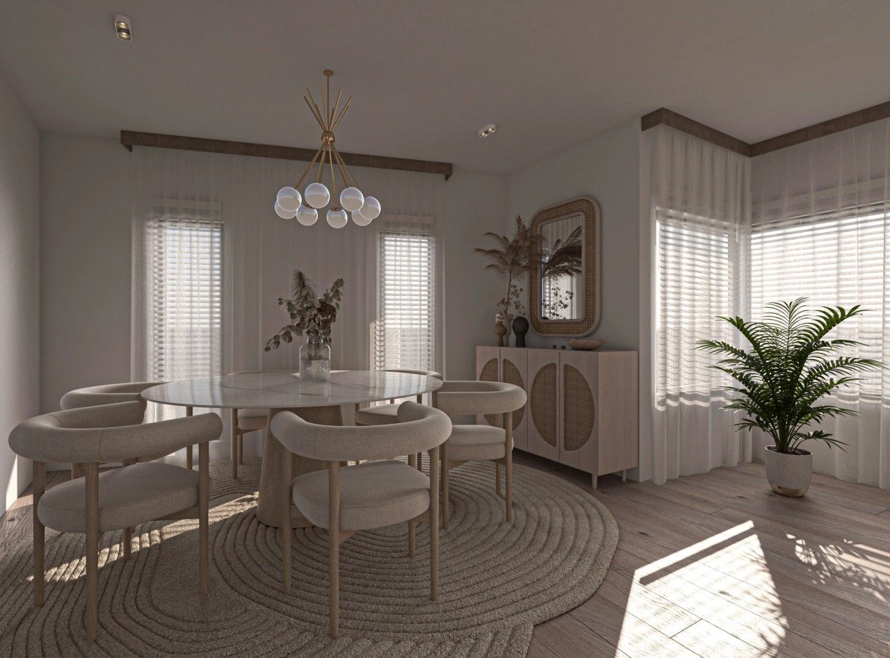 Vue intérieure de la salle à manger d’un appartement rénové à Saint-Nicolas, avec table ronde, six chaises aux formes enveloppantes, mobilier en bois clair et larges fenêtres avec voilages.