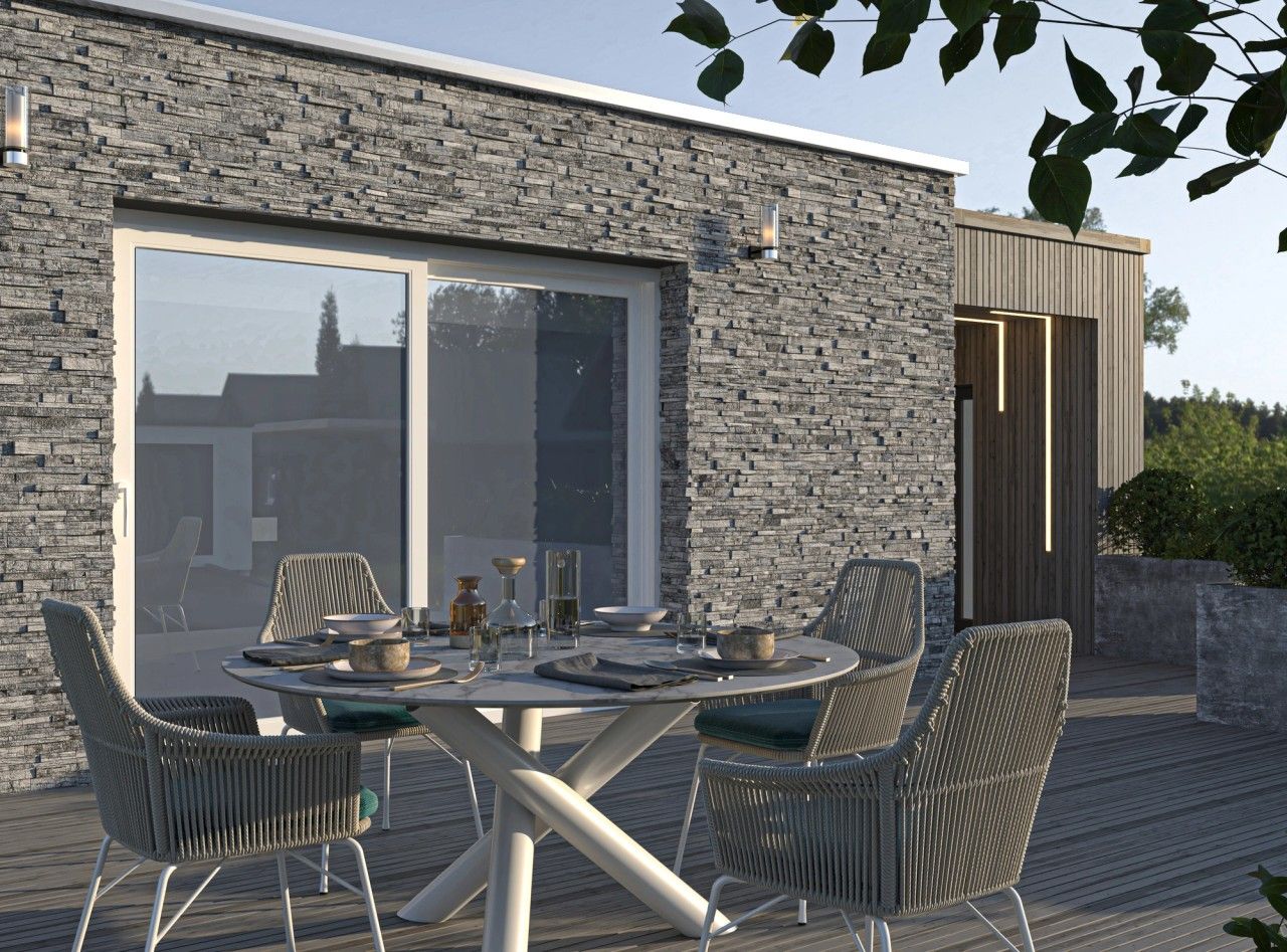 Terrasse aménagée d’une maison rénovée à Engis, avec espace repas extérieur, parement en pierre, terrasse en bois et passage latéral habillé de bois.