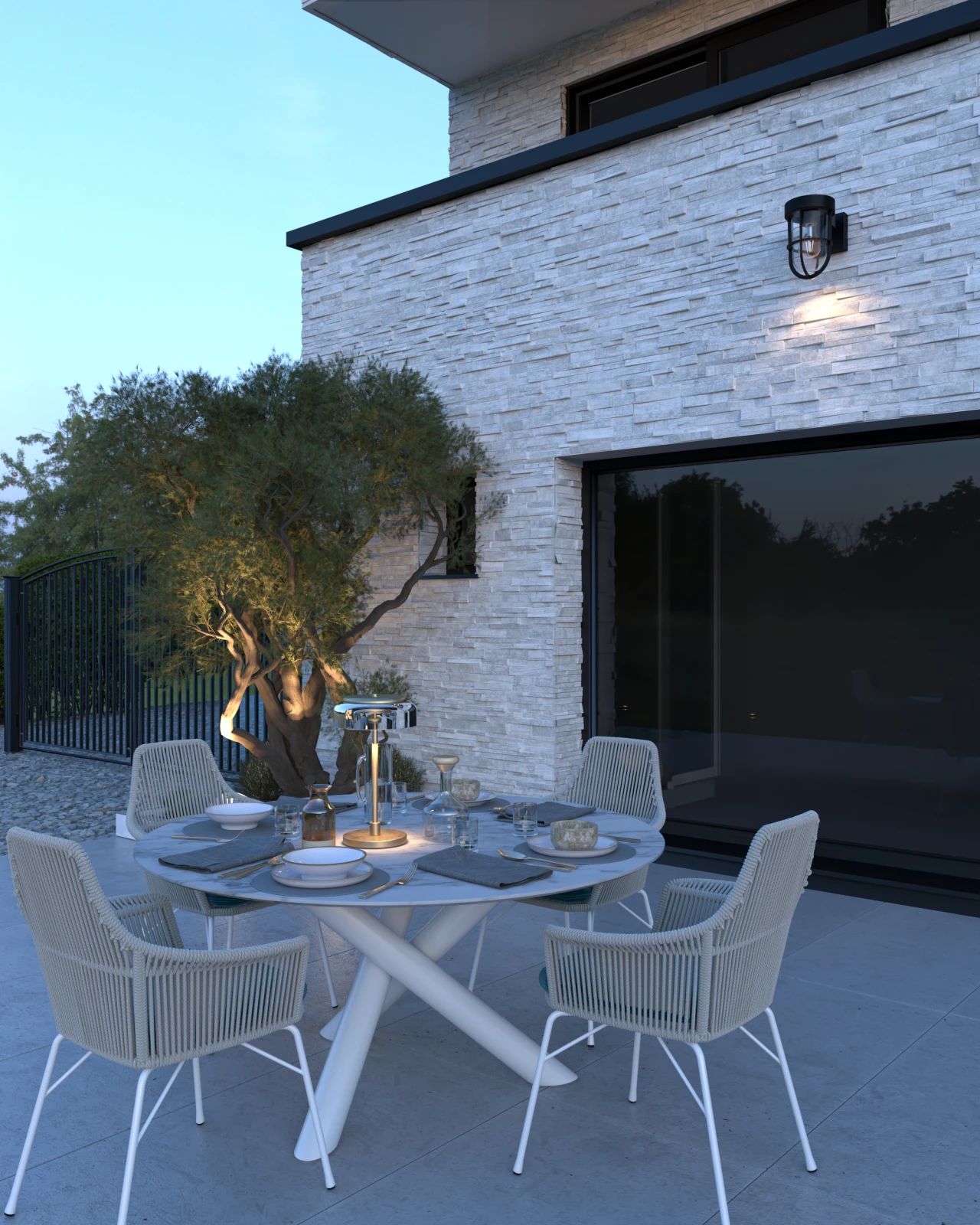 Détail de l’espace repas aménagé sur la terrasse arrière à Tongeren-Borgloon, avec mobilier contemporain, parement en brique claire et baie vitrée.