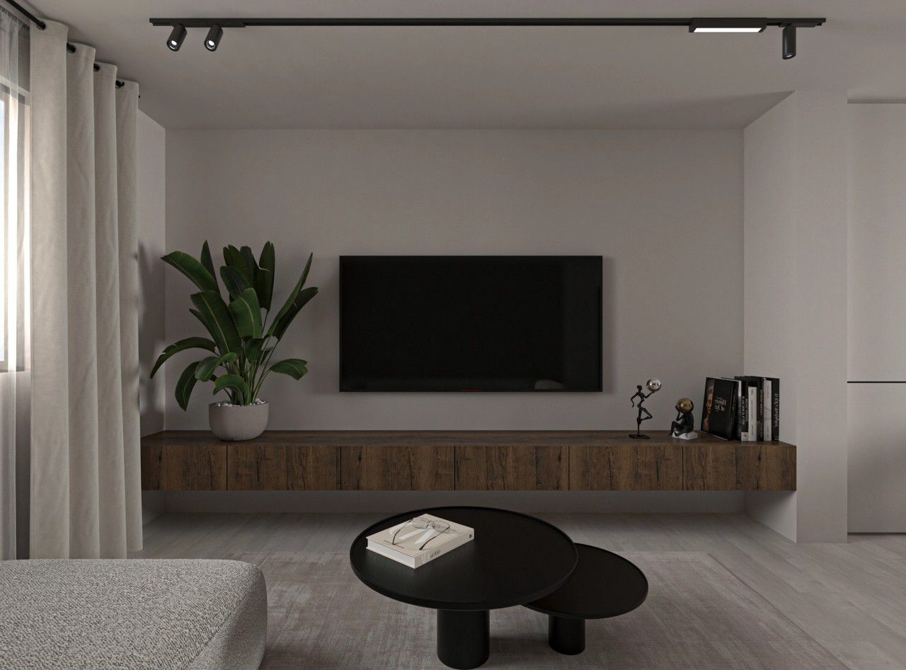 Vue du meuble TV sur mesure dans le séjour d’un appartement rénové à Herstal, avec long meuble suspendu en bois, télévision murale et éclairage sur rail.