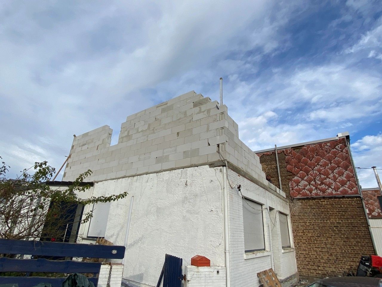 Chantier de surélévation d’une maison à Herstal, avec reconstruction du nouvel étage en blocs de béton cellulaire au-dessus du volume existant.
