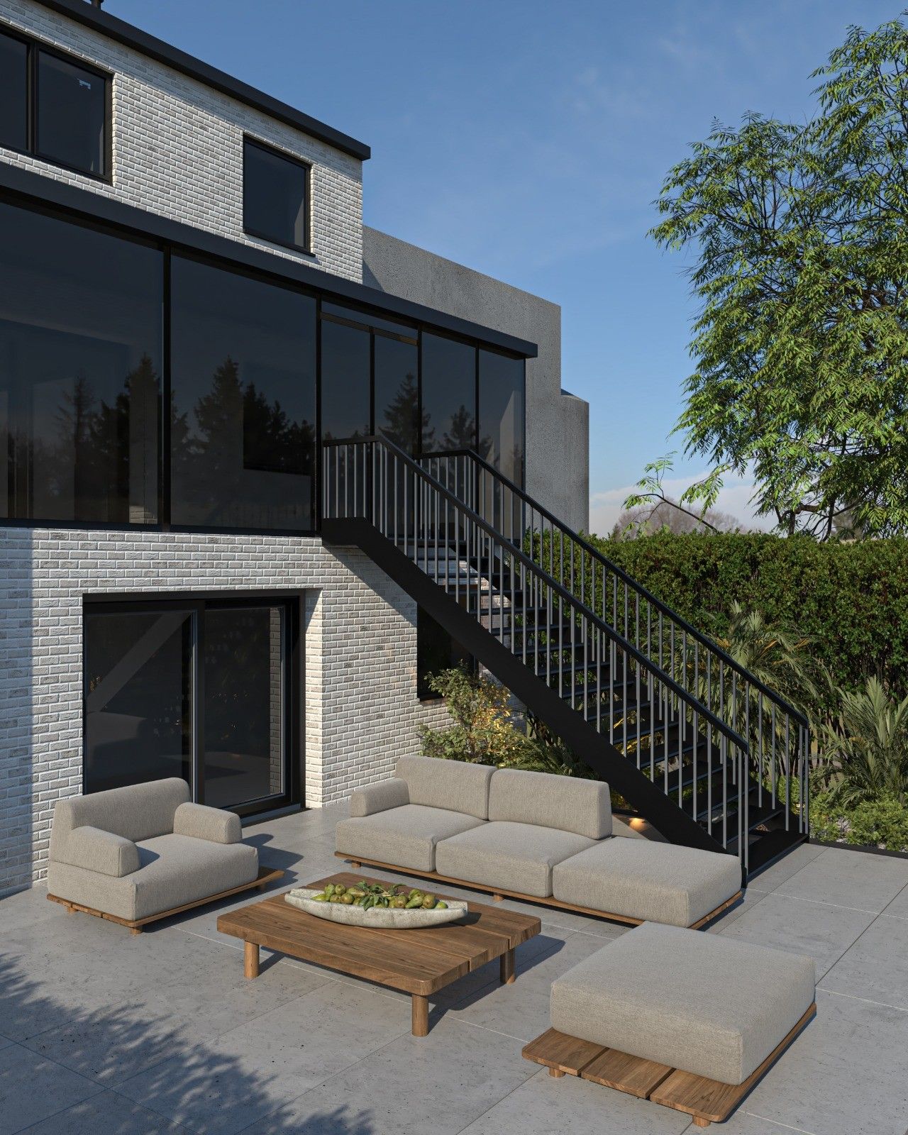 Terrasse aménagée à l’arrière d’une maison à Haccourt, avec mobilier extérieur, grandes baies vitrées et escalier métallique donnant accès au niveau supérieur.