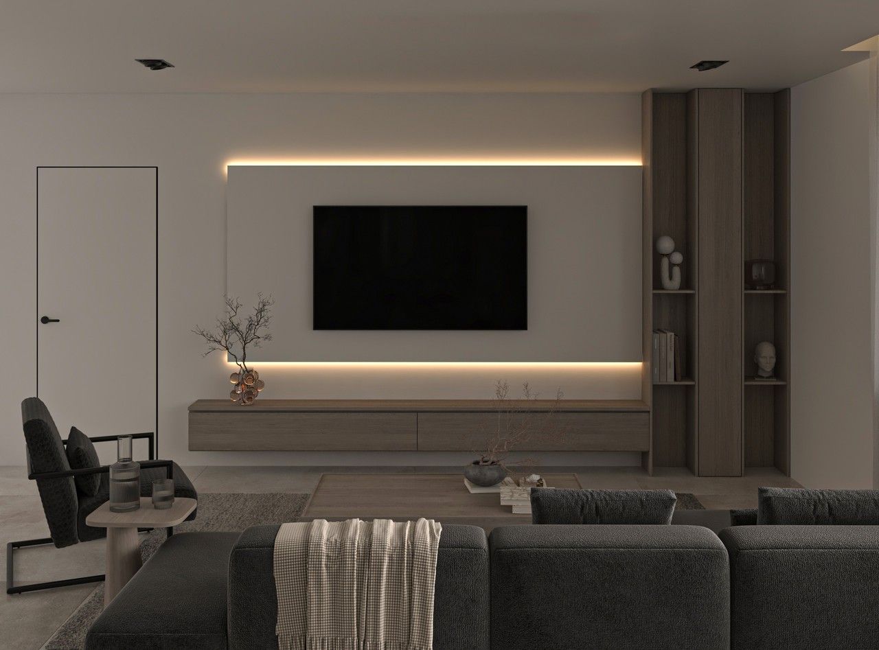 Vue du séjour d’un appartement rénové à Liège, avec mur TV rétroéclairé, meuble suspendu en bois clair, rangements intégrés et canapé sombre au premier plan.